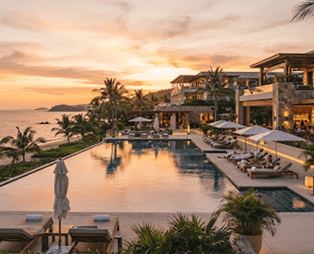 Luxury resort pool overlooking the ocean at sunset